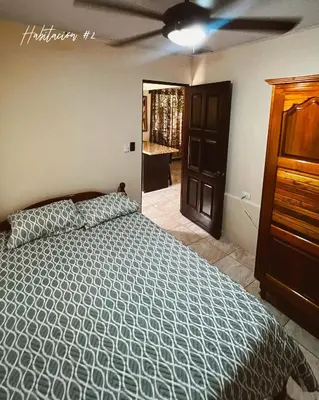a bedroom with a bed and a ceiling fan at Trébol House in Cuatro Esquinas