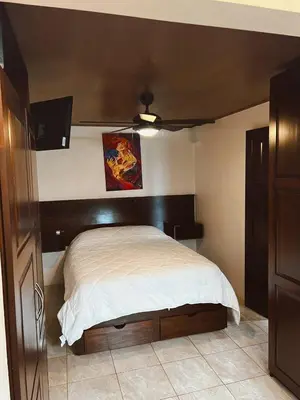a bedroom with a bed with a wooden headboard at Trébol House in Cuatro Esquinas
