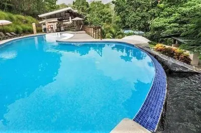a large blue swimming pool next to a river at Verde y Mar in Herradura