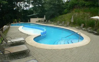 a large swimming pool with chairs around it at Verde y Mar in Herradura