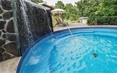 a swimming pool with a water fall at Verde y Mar in Herradura