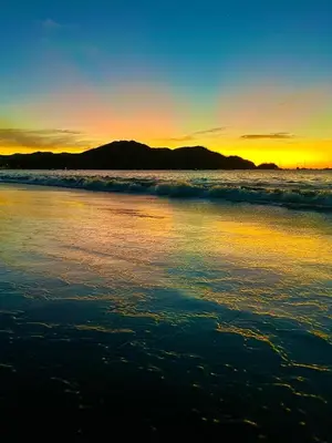 a sunset on the beach with the ocean at Aqua Vista Ground Condo in Coco