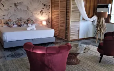 a bedroom with a bed and a table and chairs at Manuel Antonio rooms in Quepos