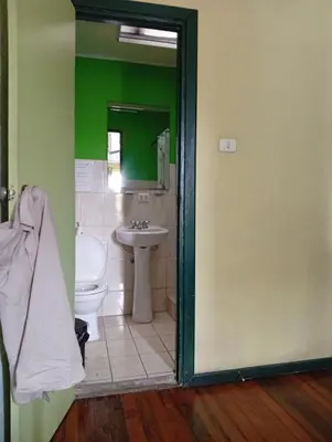 a bathroom with a sink and a toilet and a mirror at Manuel Antonio rooms in Quepos