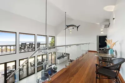a dining room with a table and chairs and windows at Villa Isla Azul in Ocotal