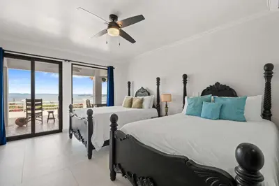 a bedroom with two beds and a ceiling fan at Villa Isla Azul in Ocotal