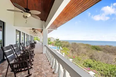 a porch with chairs and a view of the ocean at Villa Isla Azul in Ocotal