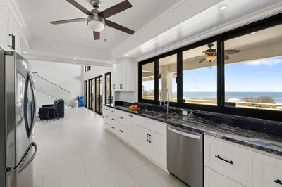 a kitchen with a ceiling fan and large windows at Villa Isla Azul in Ocotal