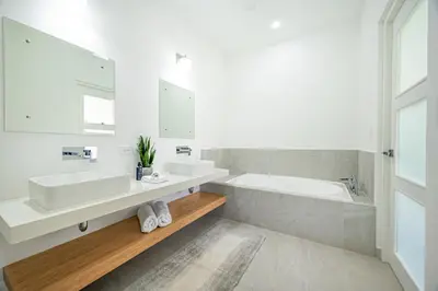a white bathroom with two sinks and a bath tub at The Enclave D9 in Playa Avellana