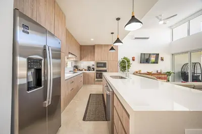 a large kitchen with a stainless steel refrigerator at The Enclave D9 in Playa Avellana
