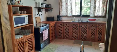 a kitchen with wooden cabinets and a sink and a microwave at Peace at the Beach in Sámara