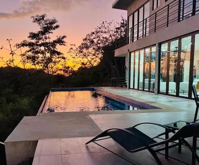 a house with a swimming pool in front of a sunset at Coco Rica Luxury Oceanview Villa Pool Concierge 4 Bedroom 6BED 5BA Playa Carrillo in Carrillo