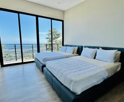 two beds in a room with a view of the ocean at Coco Rica Luxury Oceanview Villa Pool Concierge 4 Bedroom 6BED 5BA Playa Carrillo in Carrillo