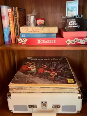 a stack of books on a shelf with a suitcase at Jungle Bungalow at Oropel Lodge in Puerto Viejo