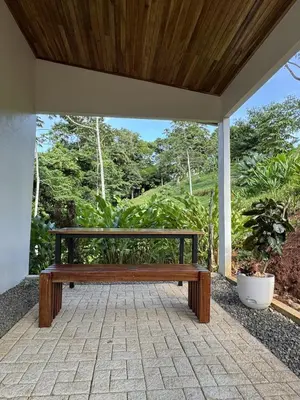 a wooden bench sitting on a patio at Jungle Bungalow at Oropel Lodge in Puerto Viejo