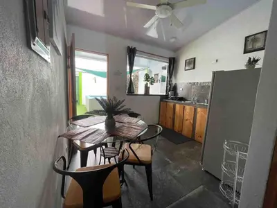 a dining room with a table and chairs and a kitchen at Apartamento con piscina privada in Uvita