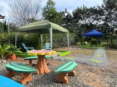 a picnic table and chairs under an umbrella at Apartamento con piscina privada in Uvita
