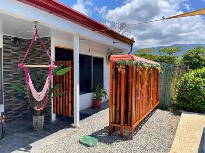 a house with a hammock outside of it at Apartamento con piscina privada in Uvita