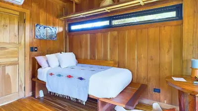 a bedroom with a bed in a wooden room at Casa Cadejo- Incredible Surf House In Playa Grande in Playa Grande