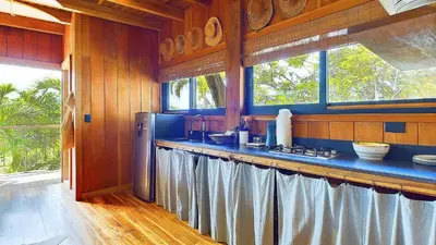 a kitchen with a counter with a sink and a refrigerator at Casa Cadejo- Incredible Surf House In Playa Grande in Playa Grande