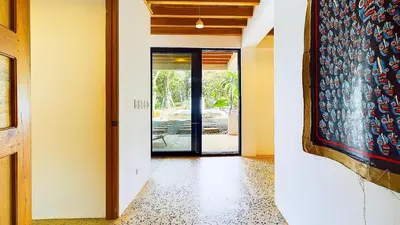 an empty hallway with a door and a painting on the wall at Casa Cadejo- Incredible Surf House In Playa Grande in Playa Grande