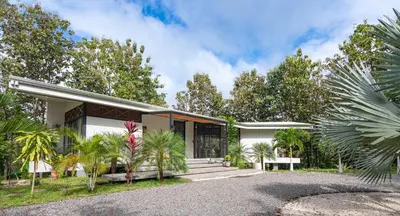 a house with palm trees in front of it at Vacation Rental Montezuma - 3BD, 3BA, Sleeps 8 in Delicias