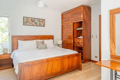 a bedroom with a wooden bed and a closet at Casa Lapas in Uvita