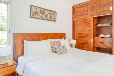 a bedroom with a white bed with a wooden headboard at Casa Lapas in Uvita