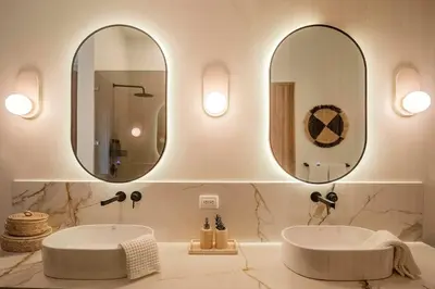 a bathroom with two sinks and two mirrors at Om at Namaste Oasis Condo in Nosara