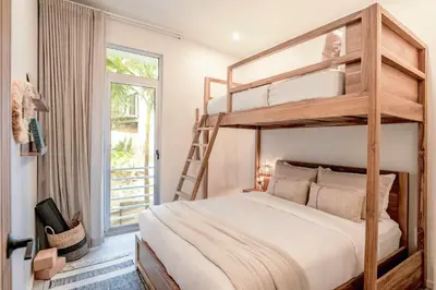 a bedroom with a bunk bed with a ladder at Om at Namaste Oasis Condo in Nosara