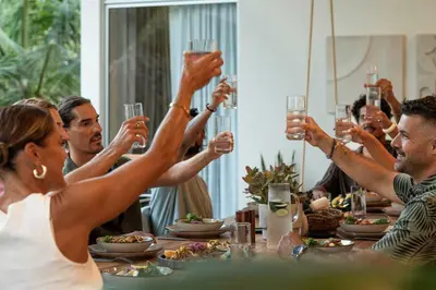 a group of people raising their glasses at a table at Om at Namaste Oasis Condo in Nosara