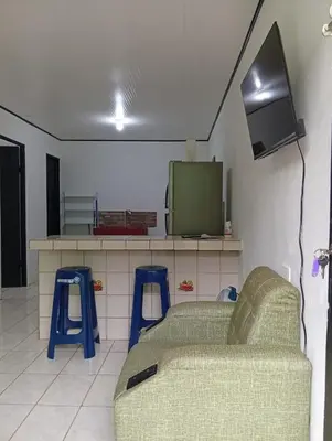 a living room with a couch and two blue stools at Apartamentos GoZu # 2 in Puerto Viejo