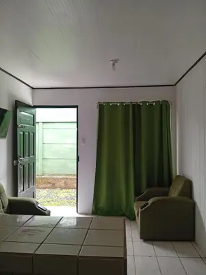 a living room with a green curtain and a door at Apartamentos GoZu # 2 in Puerto Viejo