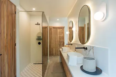 a bathroom with two sinks and a mirror at Prana at Namaste Oasis Condo in Nosara