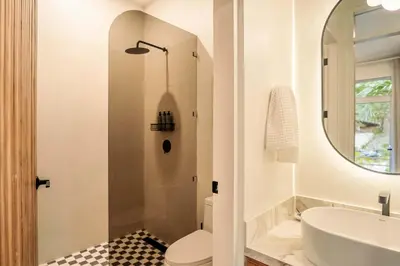 a bathroom with a sink and a toilet and a mirror at Prana at Namaste Oasis Condo in Nosara