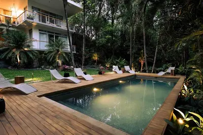 a swimming pool with chairs and a house at Prana at Namaste Oasis Condo in Nosara