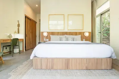 a bedroom with a large bed and a desk at Prema at Namaste Oasis Condo in Nosara
