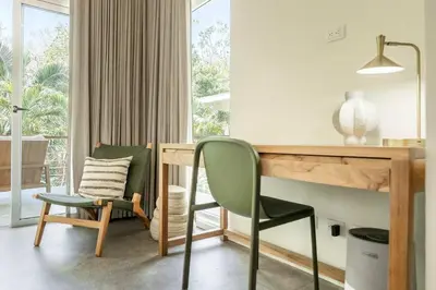 a room with a desk and a green chair at Prema at Namaste Oasis Condo in Nosara