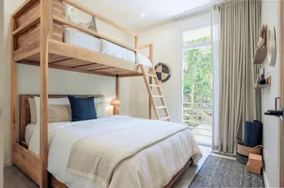 a bedroom with a bunk bed with a ladder at Prema at Namaste Oasis Condo in Nosara