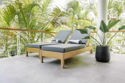 a bench sitting on a porch with a plant at Prema at Namaste Oasis Condo in Nosara