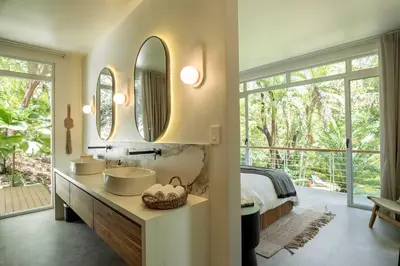 a bathroom with two sinks and two mirrors at Sukha at Namaste Oasis Condo in Nosara