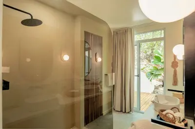 a bathroom with a tub and a glass shower at Sukha at Namaste Oasis Condo in Nosara