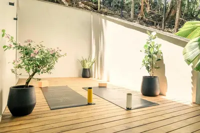 a balcony with two potted plants and a yoga mat at Sukha at Namaste Oasis Condo in Nosara