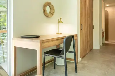a wooden desk with a chair and a mirror at Sukha at Namaste Oasis Condo in Nosara