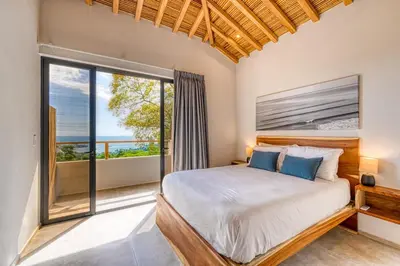 a bedroom with a bed and a large window at Villa Kañik - Luxury Retreat with Concierge Services in Dominical