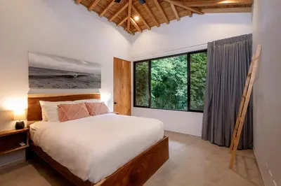 a bedroom with a bed and a large window at Villa Kañik - Luxury Retreat with Concierge Services in Dominical