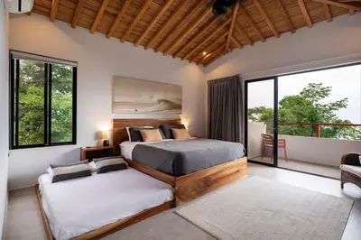 a bedroom with two beds and a large window at Villa Kañik - Luxury Retreat with Concierge Services in Dominical