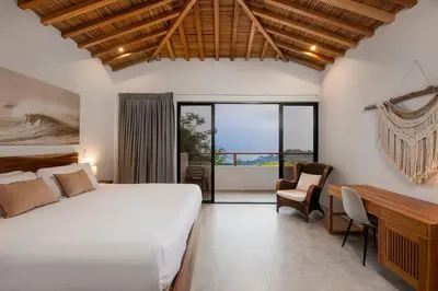 a bedroom with a large bed and a desk with a desk at Villa Kañik - Luxury Retreat with Concierge Services in Dominical