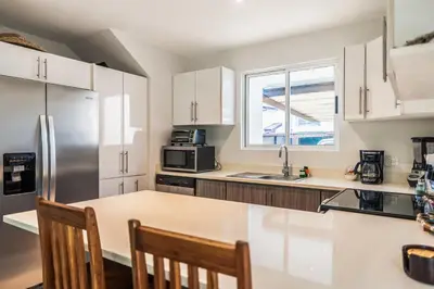 a kitchen with white cabinets and a stainless steel refrigerator at Ciudad del Mar 70 in Jacó