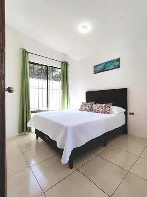 a bedroom with a bed and a large window at Casa Chika, Playa Grande Guanacaste, Casa Completa in Cuajiniquil